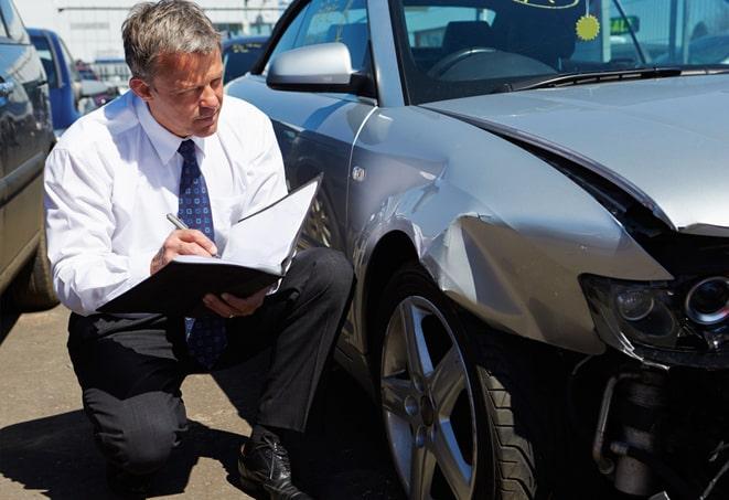 white sedan parked in front of an auto insurance office